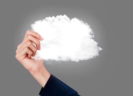Close up business woman holding cloud shape at grey background. Cloud computing concept.の写真素材