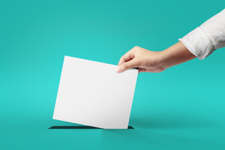 Woman hand holding ballot paper for election at green background. vote concept.