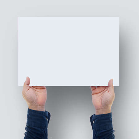 Close up hands holding blank paper for work top view.