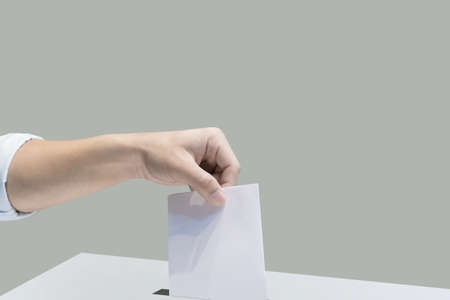 Hand holding ballot paper for election vote concept at place election background.の写真素材