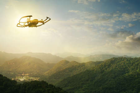 Drone flying overhead in cloudy sunset sky.