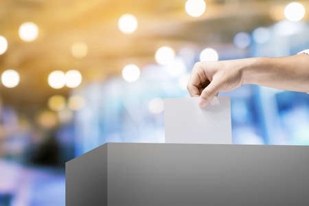 Hand holding ballot paper for election vote concept at place election background.の写真素材