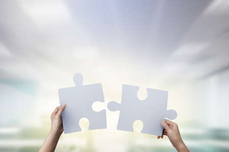 Closeup hands of connecting jigsaw puzzle.