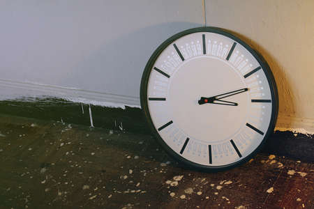Wall clock on the wooden floor  Process in vintage style color 