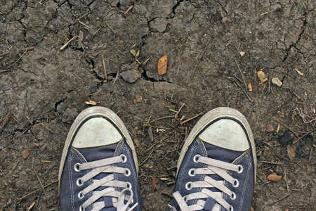Sport sneakers from an aerial view on cracked ground, Blue shoes, Top view.の写真素材