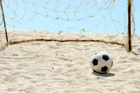 Football on a Beach, soccer leather ball on beach, with sea in the background.の写真素材