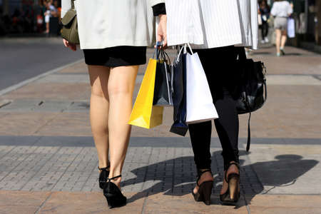 Closeup of women holding shopping bags on the street, Let's go shopping, Shopaholic women.の写真素材