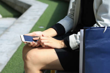 Close up of a woman using mobile smart phone outdoor, Office lady working out.の写真素材