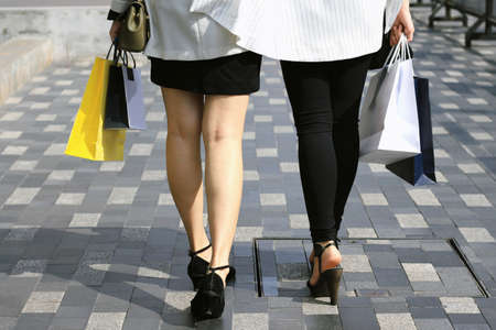 Closeup of women holding shopping bags on the street, Let's go shopping, Shopaholic women.の写真素材