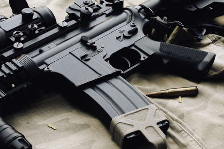 Close-up of a M4A1 weapons and military equipment for army, Assault rifle gun and pistol on camouflage background.の写真素材