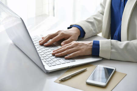Working woman in the office, Woman sitting at desk and working at laptop computer.の写真素材