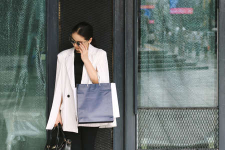 Shopping woman in city, Portrait of stylish young woman holding shopping bags on the street.