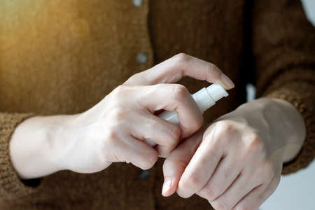 Closeup shot of hands applying moisturizer. Beauty woman holding a cosmetic bottle containers of...