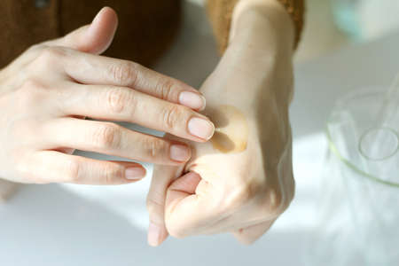 Closeup shot of hands applying moisturizer. Beauty woman and skin cream.