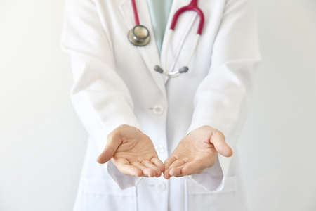 Doctor presenting blank palm of her hand, Close up of female doctor holding something.の写真素材