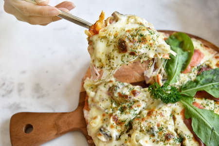 Close up Italian pizza slice with melting cheese, Selective focus.の写真素材