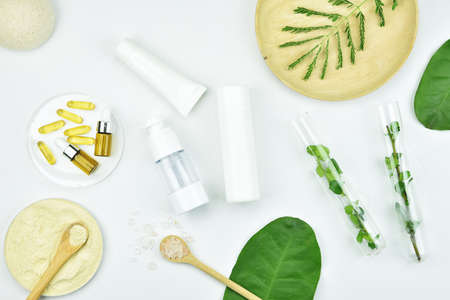 Cosmetic bottle containers with green herbal leaves, Blank label package for branding mock-up, Natural organic beauty product concept.の写真素材