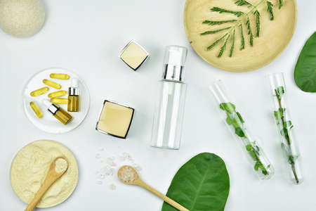 Cosmetic bottle containers with green herbal leaves, Blank label package for branding mock-up, Natural organic beauty product concept.の写真素材