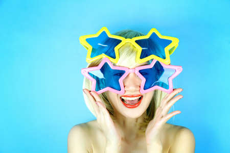 Funny girl wearing star shaped glasses, Playful girl with funny glasses, Happy naughty blonde hair woman with Large glasses. Party time.の写真素材