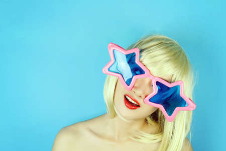 Funny girl wearing star shaped glasses, Playful girl with funny glasses, Happy naughty blonde hair woman with Large glasses. Party time. (Vintage Style Color)の写真素材