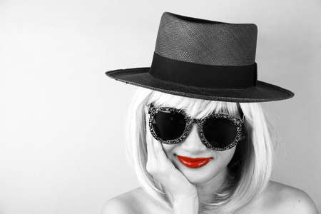 Red lips in black and white, Glamor stylish beautiful young woman model with red lips and hipster sunglasses, Young sexy girl in brown summer hat.の写真素材