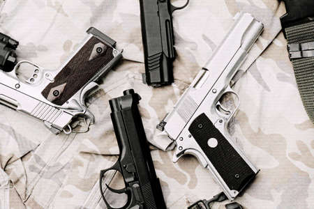 Many Guns on Military texture. Handguns on camouflage background. 9mm, 11mm Pistols. (Process With TV Scan line effect)の写真素材