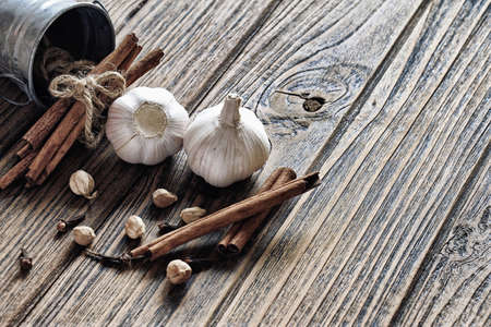 Cinnamon sticks and Fresh garlic on wooden background, Healthy Cuisine ingredients. (Color Process)の写真素材