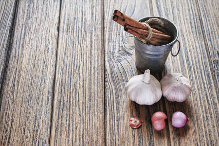 Cinnamon sticks and Fresh garlic on wooden background, Healthy Cuisine ingredients. (Color Process)の写真素材