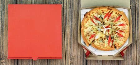Pizza and the delivery box on wooden background, Fast food.の写真素材