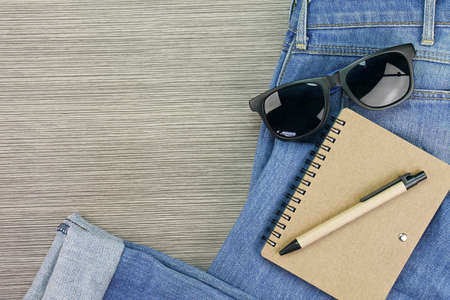 Eco-friendly concept. Blue Jeans, sunglasses and brown paper stationery.の写真素材