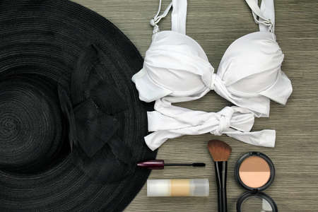 Fashion swimsuit bikini and makeup set, Summer clothes, mascara, concealer, blushes and wide brim sun hat. Stylish luxury accessories.の写真素材