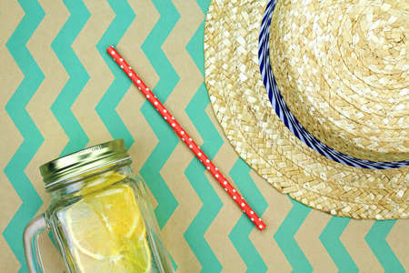 Summer accessories, Fresh summer drink and straw hat, Infused water with organic oranges.の写真素材