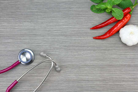 Stethoscope and herb on a wooden background. Medical equipment, Healthy food eating concept.
