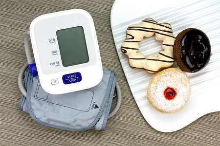Digital Blood Pressure Monitor and Donut, Unhealthy food, Confectionery. High sugar. (Vintage Style Color)の写真素材