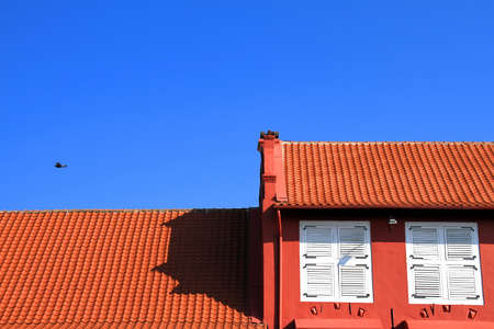 Architectural detail of colorful building exhibiting the Spanish or Mexican influence with roof tiles, stucco walls and wooden beams.の写真素材