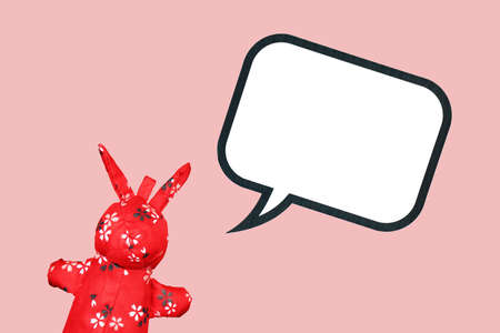 Red Rabbit cloth toy with blank speech bubble on pink background, Chinese traditional doll with copyspace.の写真素材