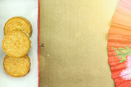 Chinese moon cake and red oriental chinese fan for celebrate in Mid autumn festival. (Moon cake day) Above angle. (Lighting Effect Processed)の写真素材