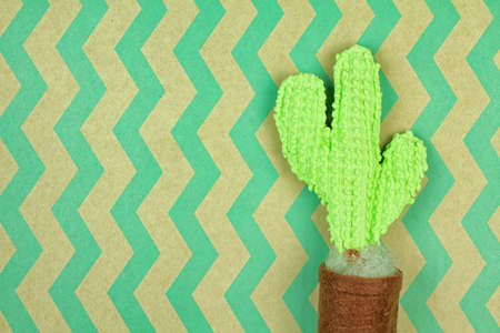 Knitted cactus on green wavy pattern brown paper, Home decoration, Eco-friendly concept.の写真素材