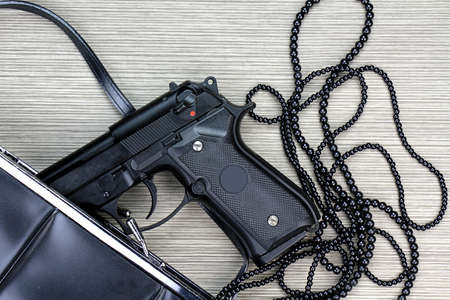 Woman bag with gun hidden, Handgun and accessories falling from a woman's purse.の写真素材