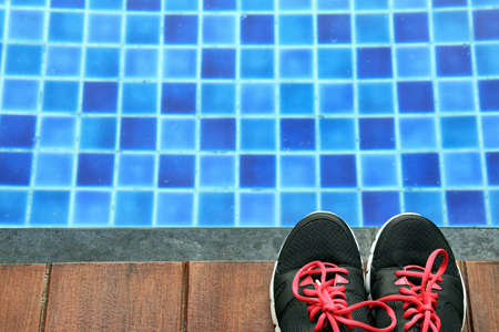 Running shoes on the side of a swimming pool, Exercise concept.の写真素材