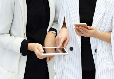 Businesswomen partners looking at tablet computer and smart phone, Business discussion.の写真素材