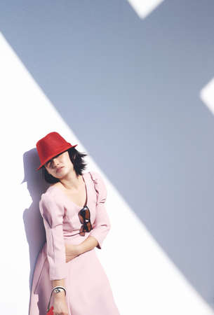 Young asian woman with red hat lying against the wall, Portrait of beautiful girl.の写真素材