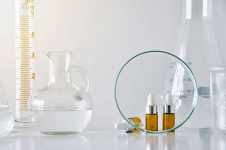 Cosmetic brown bottle containers  and scientific glassware, Focus on blank label package for branding mock-up, Research and develop beauty skincare product concept.の写真素材