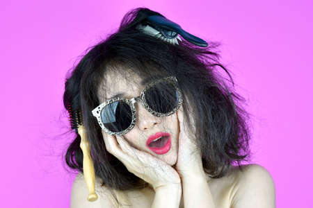 Dry and damaged hair problems, Young woman worry about her messy tangled hair, Funny girl and bad hair day.の写真素材