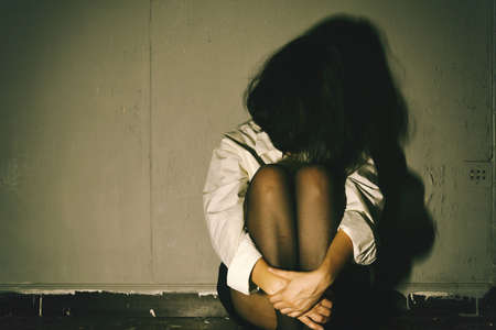 Depressed and frustrated, Sad woman sitting in the dark room, Mental health concept.の写真素材