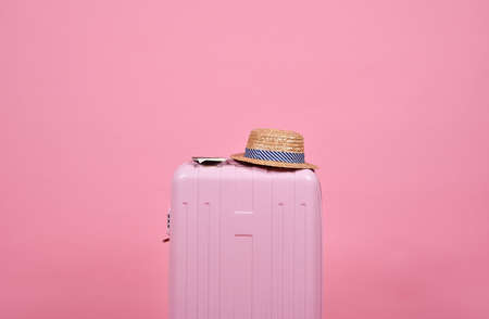 Traveler pink suitcase and passport document over pink background, Journey and travel concept.