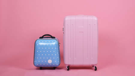 Set of luggage suitcase, Traveler pink suitcase and blue cabin size luggage on pink background, Journey and travel concept.の写真素材