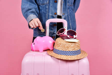 Money cash saving for travel concept, Traveler and pink suitcase, Passenger and passport document over pink background.の写真素材