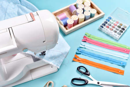 Pastel color background, Dressmaker and designer desk, Sewing machine and handcraft accessories.