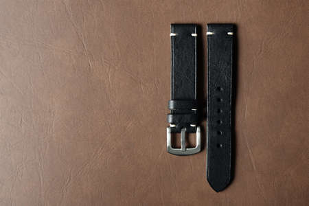 Black leather watch strap with stainless buckle on leather background, Craft and handmade watch...